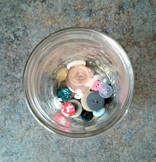 A few buttons in the bottom of a mason jar