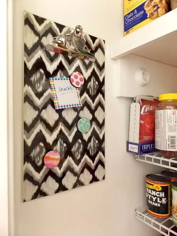 Decorative clipboard hanging on wall of pantry