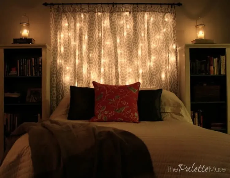 Bed with headboard made of curtains and string lights