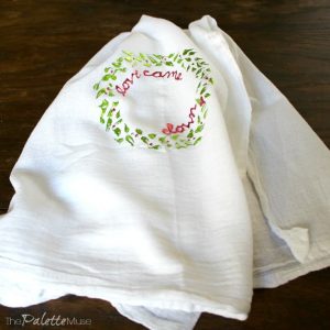 Tea towel decorated with a deco foil wreath in green and pink