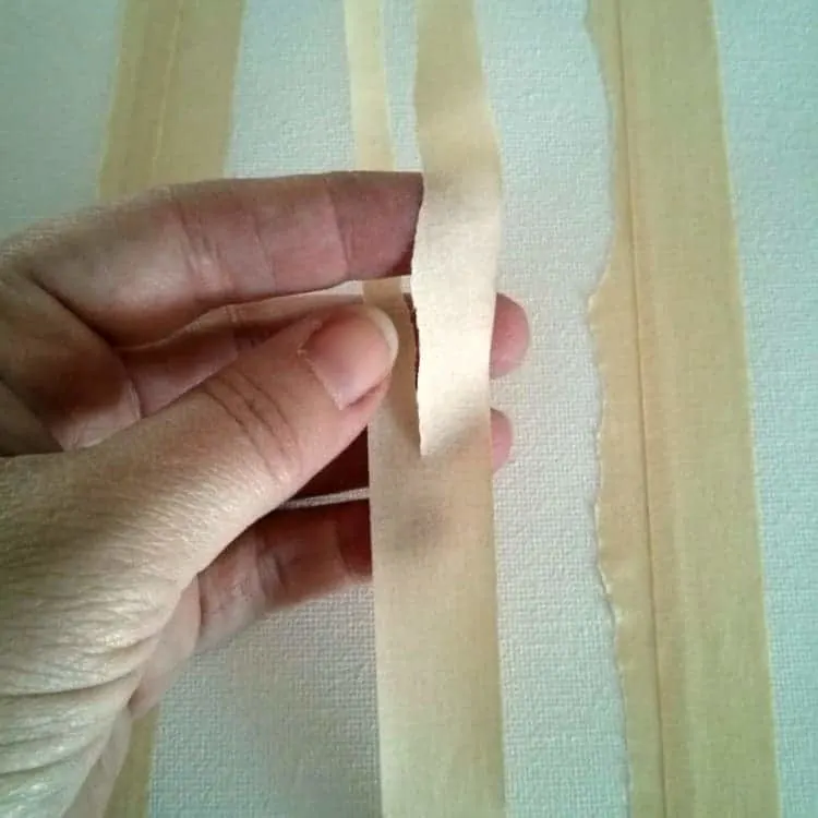 Tearing masking tape strips to make tree trunks
