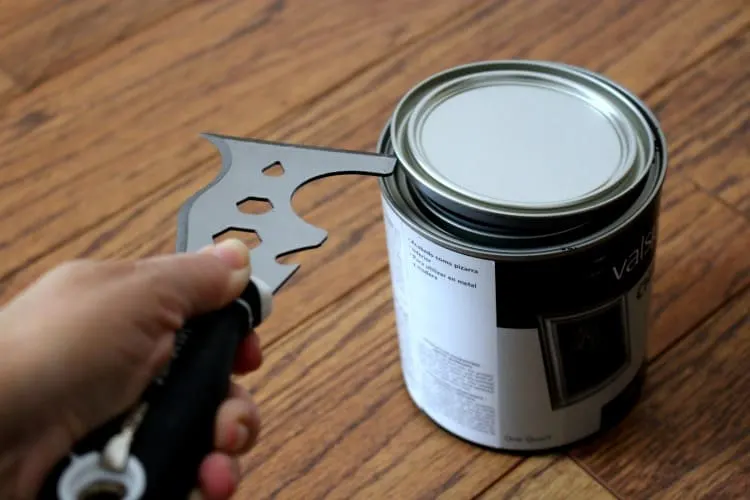 Painter's Tool prying lid off paint can