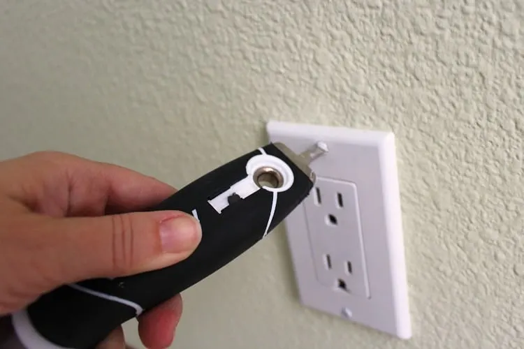 Using the screwdriver on a painter's tool to remove outlet cover