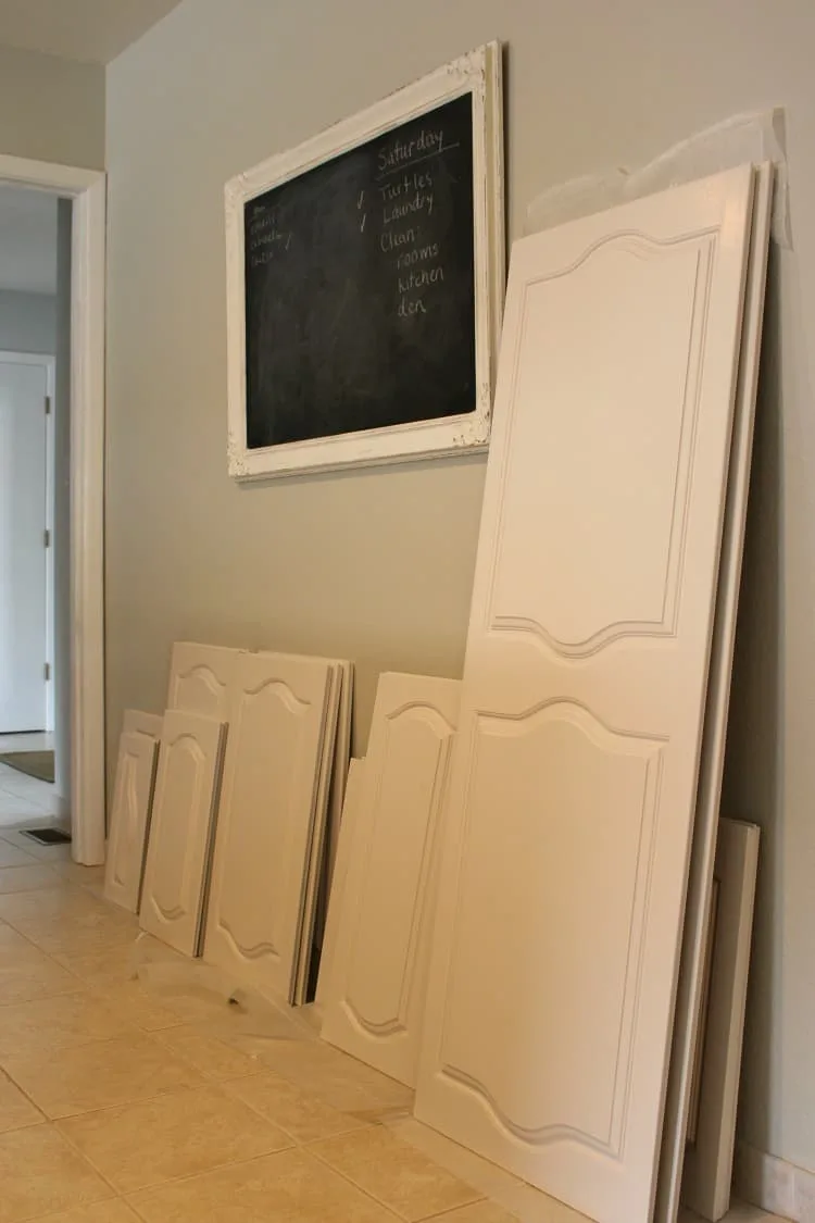 White painted kitchen cabinet doors leaning on the wall to dry