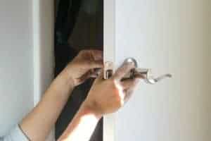 Holding two sides of a door handle together while screwing in bolts