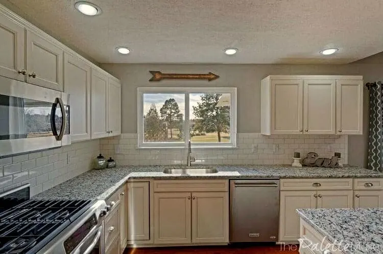 Home staging with a white kitchen and gray granite countertops