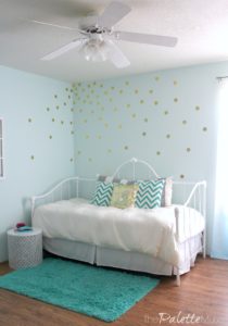 Fresh bedding and a gold vinyl polka dot wall treatment make this bedroom pop!