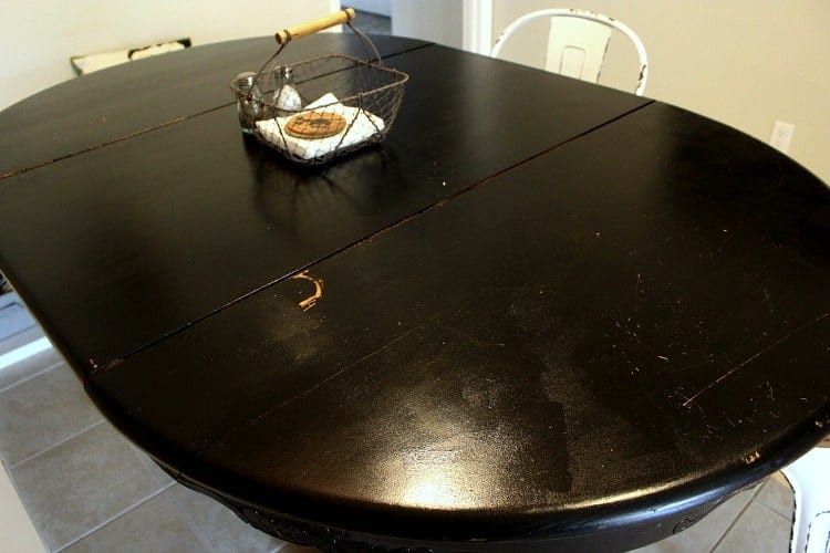 Glossy black table top with scratches all over it.