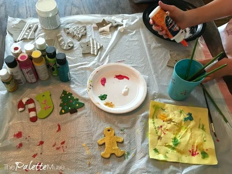 Decorating concrete ornaments with craft paint, glitter, and glue.