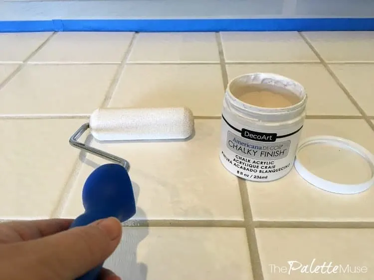 Rolling chalk paint over tile for the base coat of the stencil