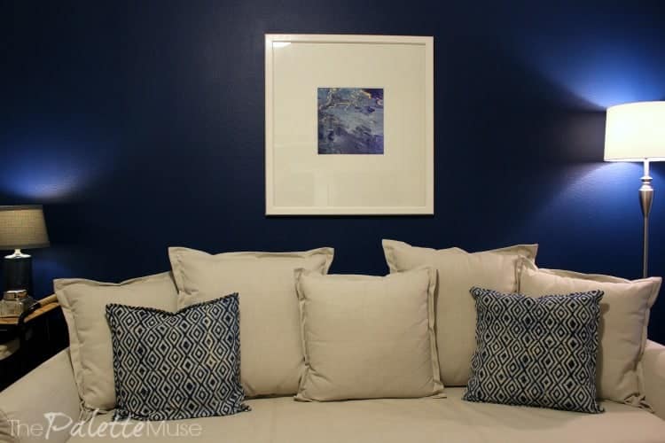 Dark blue accent wall with large framed poured paint artwork in the home office makeover.