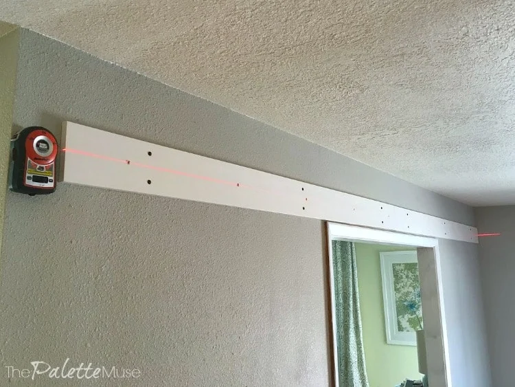 Using a laser level to install barn doors.