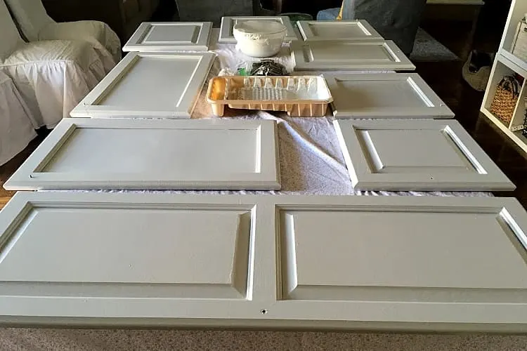 Painted cabinet doors are drying on a table top while I'm working on painting the countertops.
