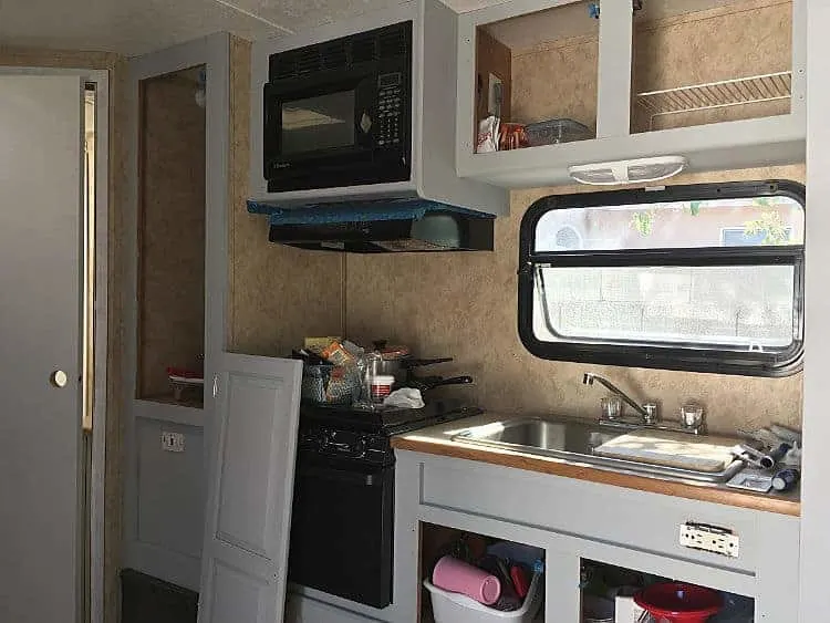 Laminate cabinets with doors removed and in process of painting frames.