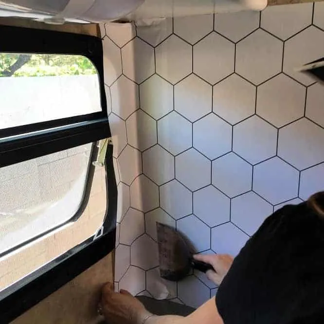 Applying removable wallpaper in gray on white hexagon pattern