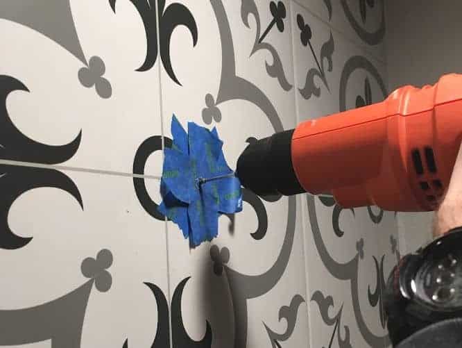 Drilling into tile which has been covered with blue tape to prevent chipping.