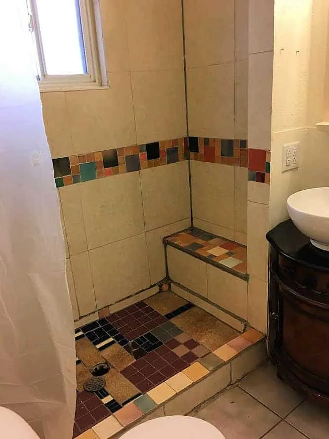 Tiny bathroom with shower tile falling apart