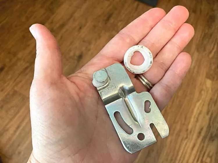 A broken roller and bracket from the top of a sliding closet door