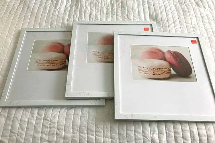 Three framed prints of pink macarons.