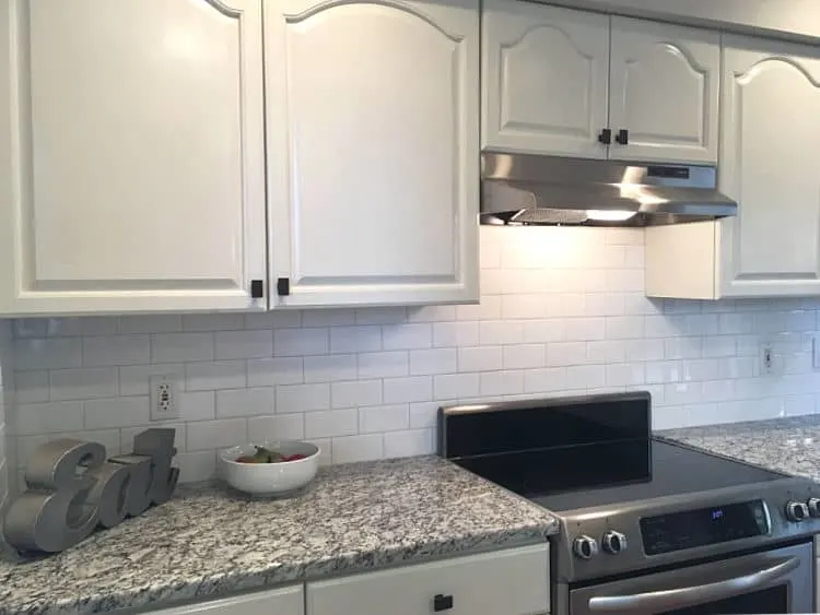 White kitchen cabinets with gray granite countertop