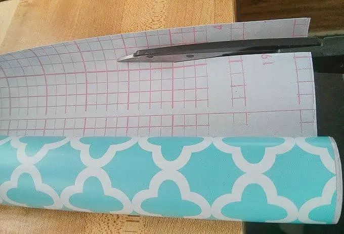 Cutting adhesive shelf paper using grid as a guide