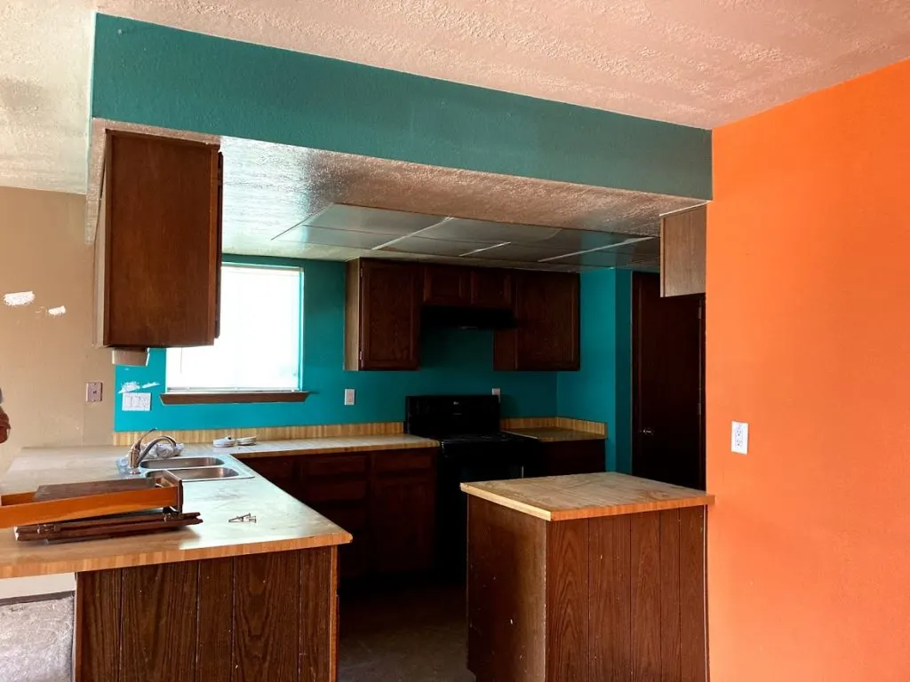 Flip House Before. orange and teal colored walls in kitchen