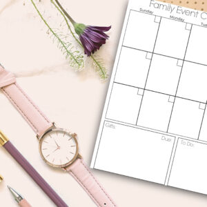Family Event Calendar on table with watch and pens