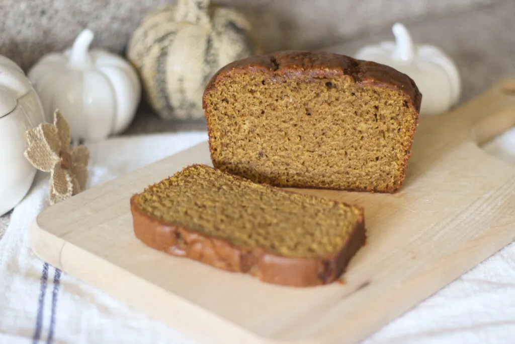 Perfect pumpkin bread sliced on bread board to show moist texture inside