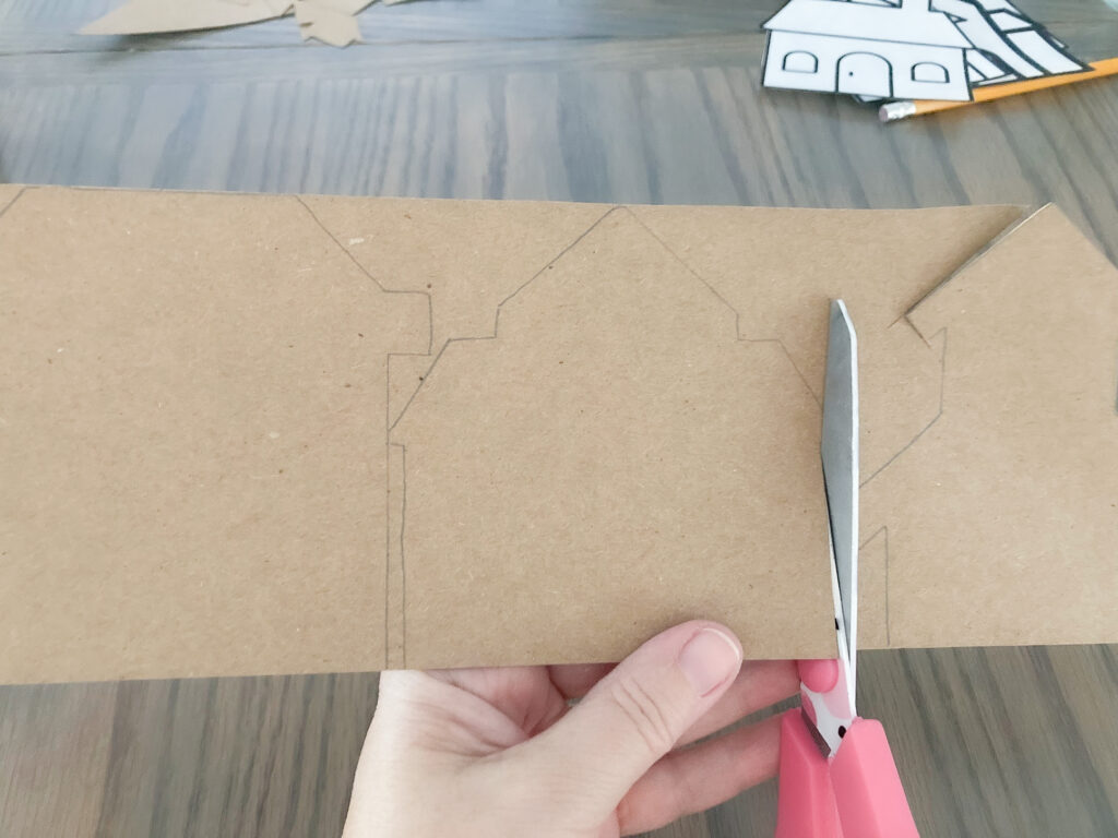 Cutting house shapes out of brown paper.