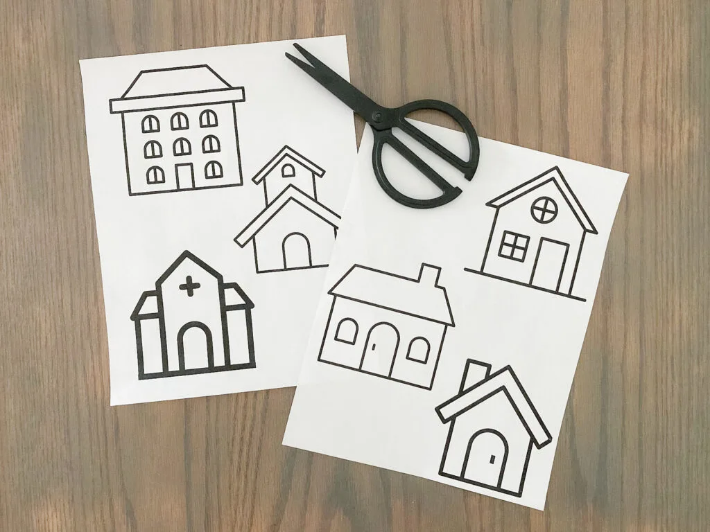 Gingerbread house paper templates laying on a table with scissors.