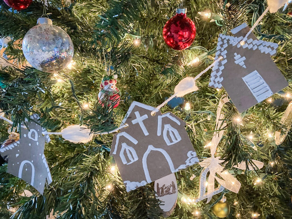 Christmas tree with a banner made from brown paper, decorated to look like gingerbread houses.