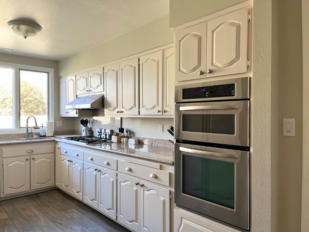 White painted kitchen cabinets with stainless steel appliances.