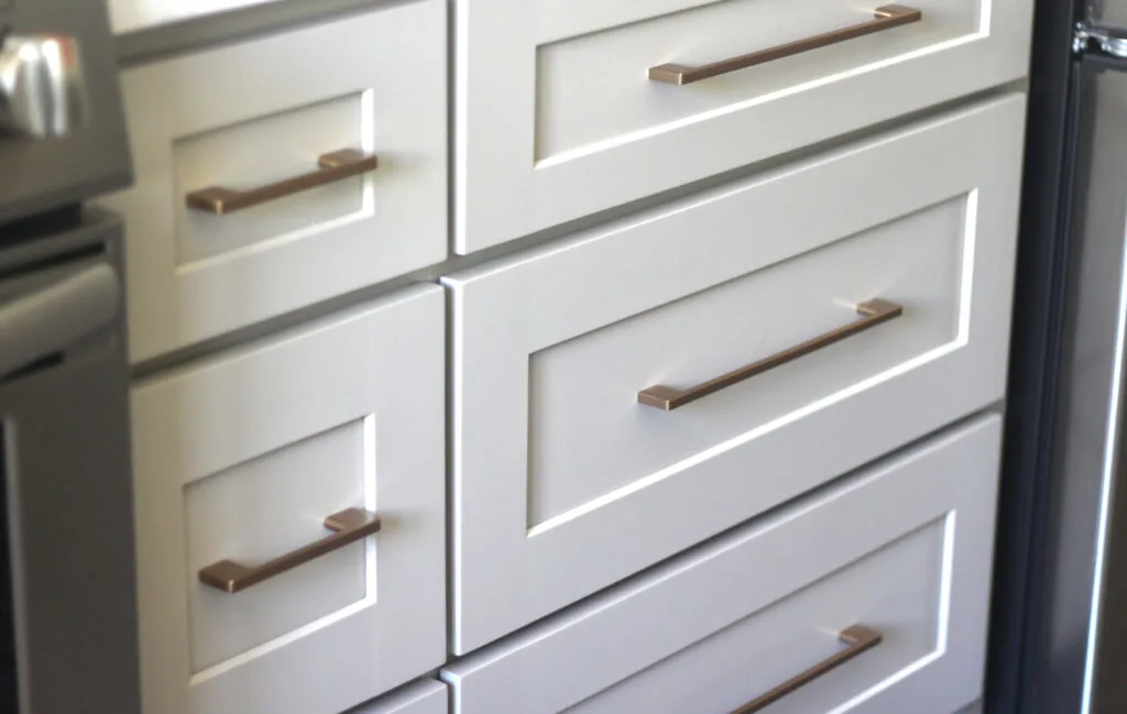 Sand colored cabinets with matte champagne drawer pulls