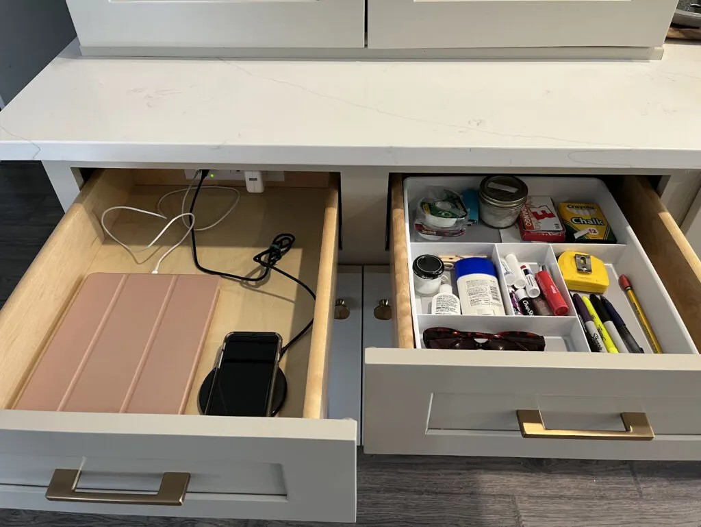 A view of two well organized kitchen drawers, one converted to a charging drawer with phone and ipad plugged in out of sight.