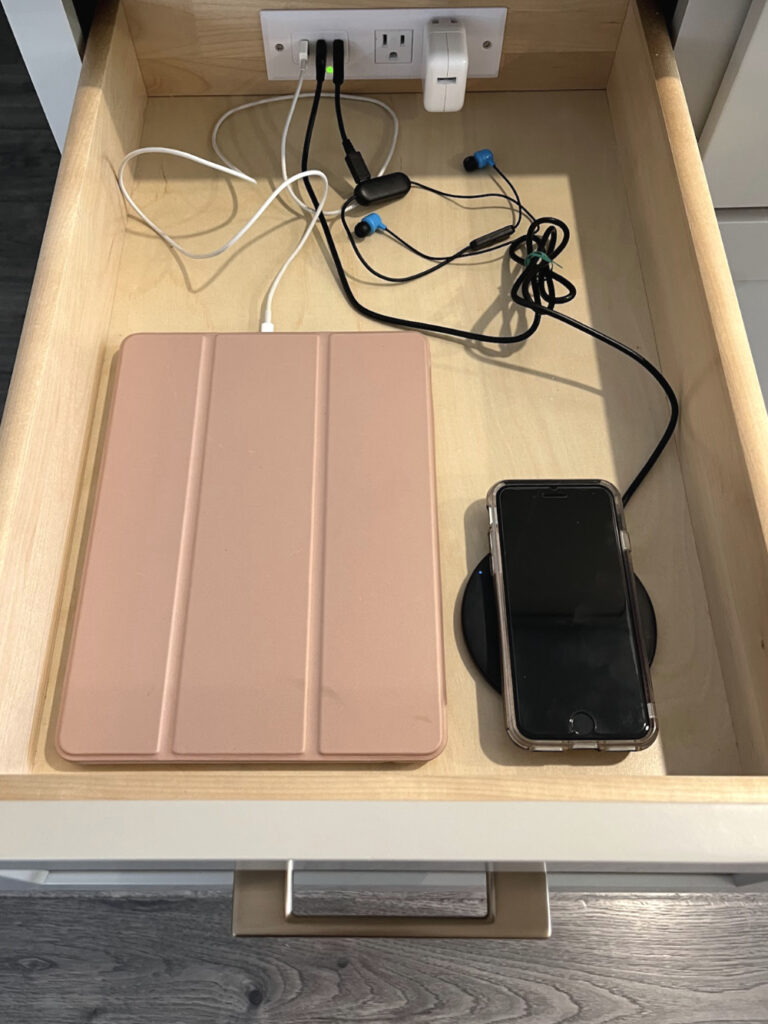 A charging drawer made out of a regular kitchen drawer with a charging strip mounted to the back.