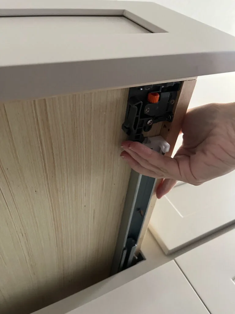 Removing a kitchen drawer by releasing a lever under the drawer.