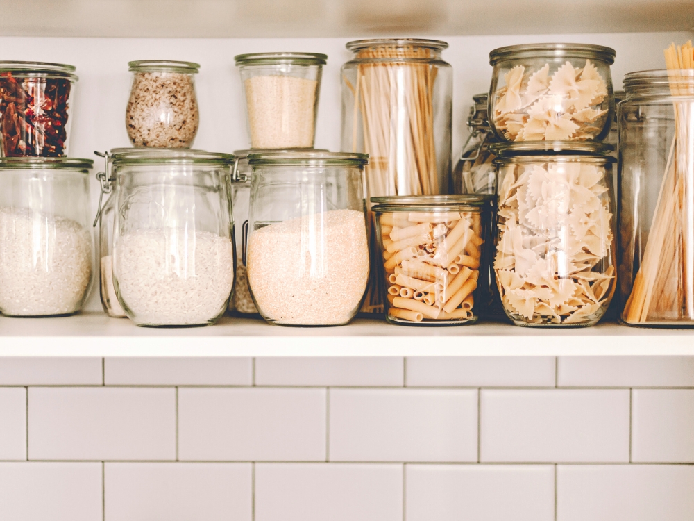Organized glass storage jars on a kitchen shelf