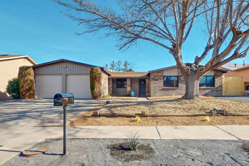 Our flip house exterior with new paint, garage doors, mailbox, and landscaping.