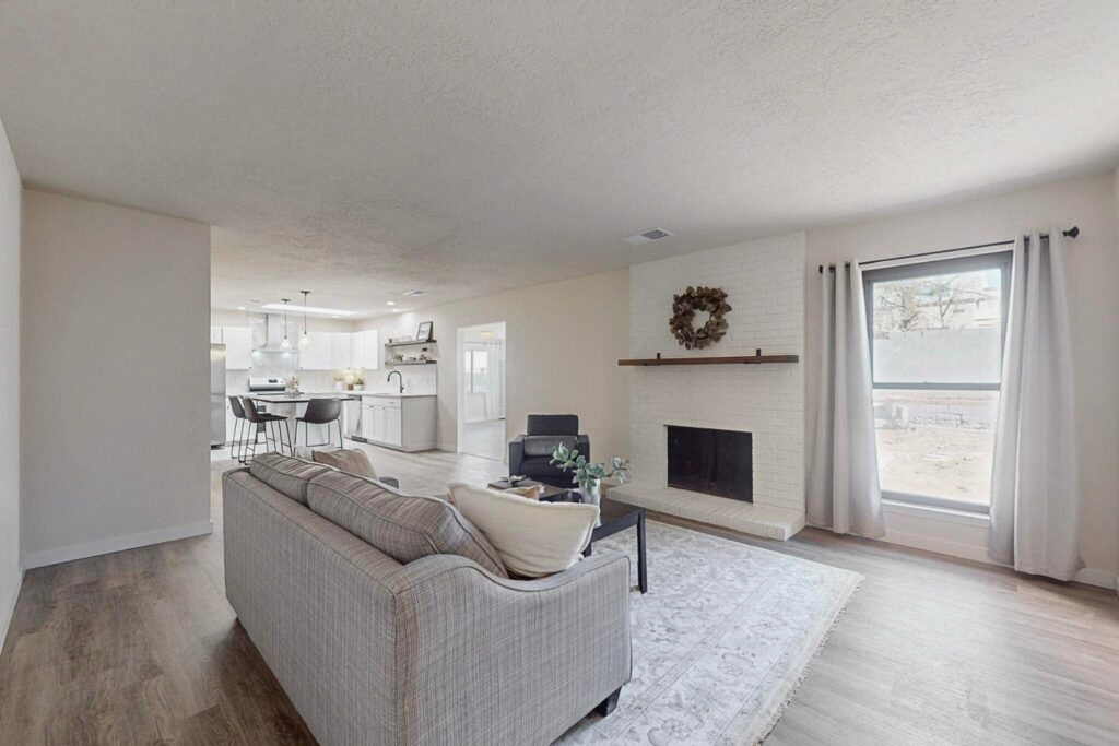 The flip house living room with while painted fireplace and cozy staging.