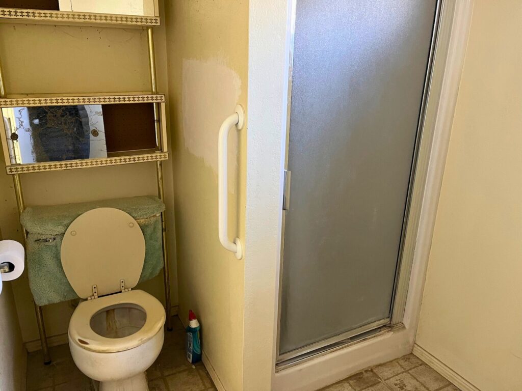 A small toilet and tiny shower were crammed into this main bathroom.