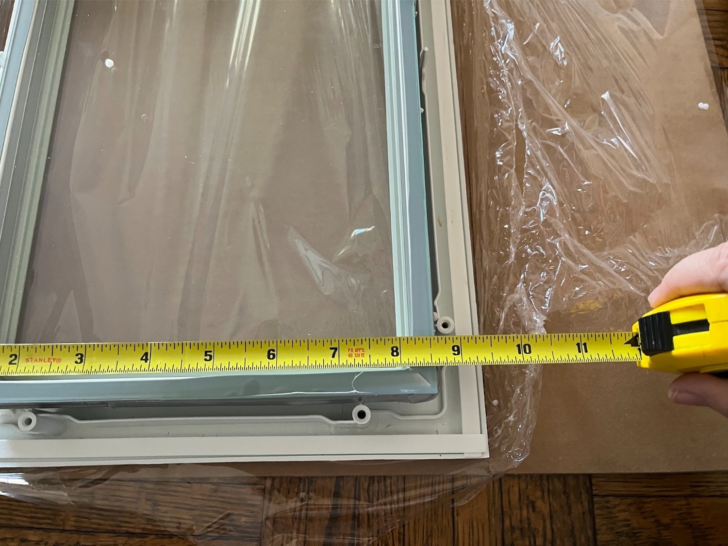 A measuring tape showing 8.5 inches at the edge of a window to be installed.