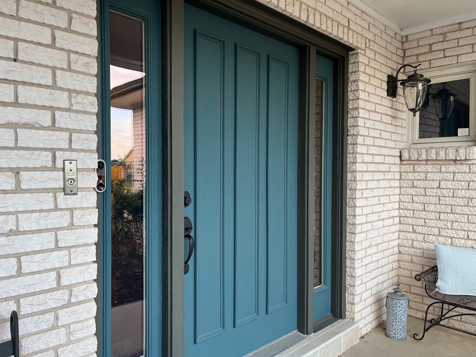Freshly painted dark teal front door with side lights.